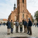 Konzervativní oblečení turistů před historickým kostelem v Polsku